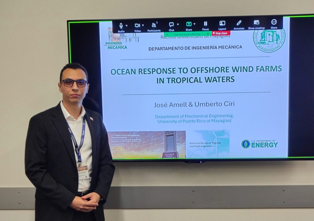 José Luis Amell Hernández stands in front of a projection of his presentation title slide.